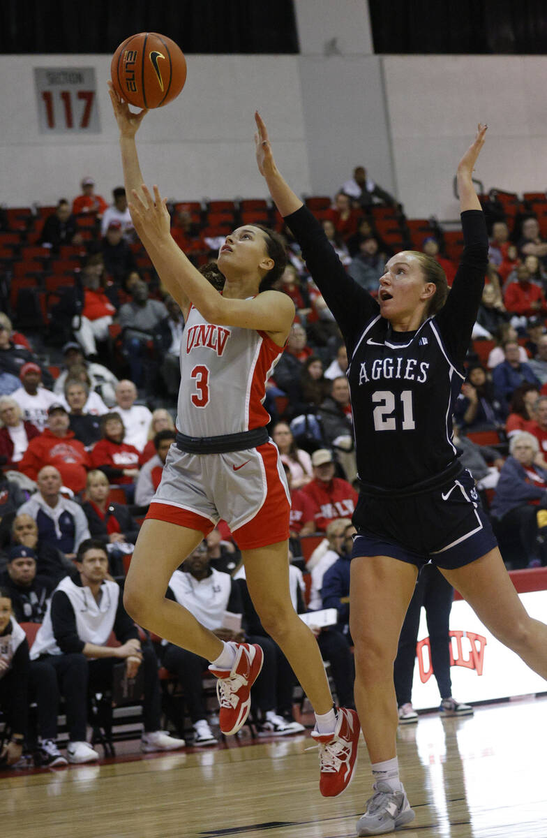 UNLV Lady Rebels guard Kiara Jackson (3) lays up a ball as Utah State Aggies guard Mayson Kimba ...