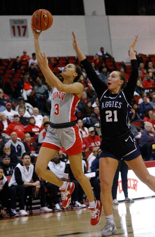 UNLV Lady Rebels guard Kiara Jackson (3) lays up a ball as Utah State Aggies guard Mayson Kimba ...