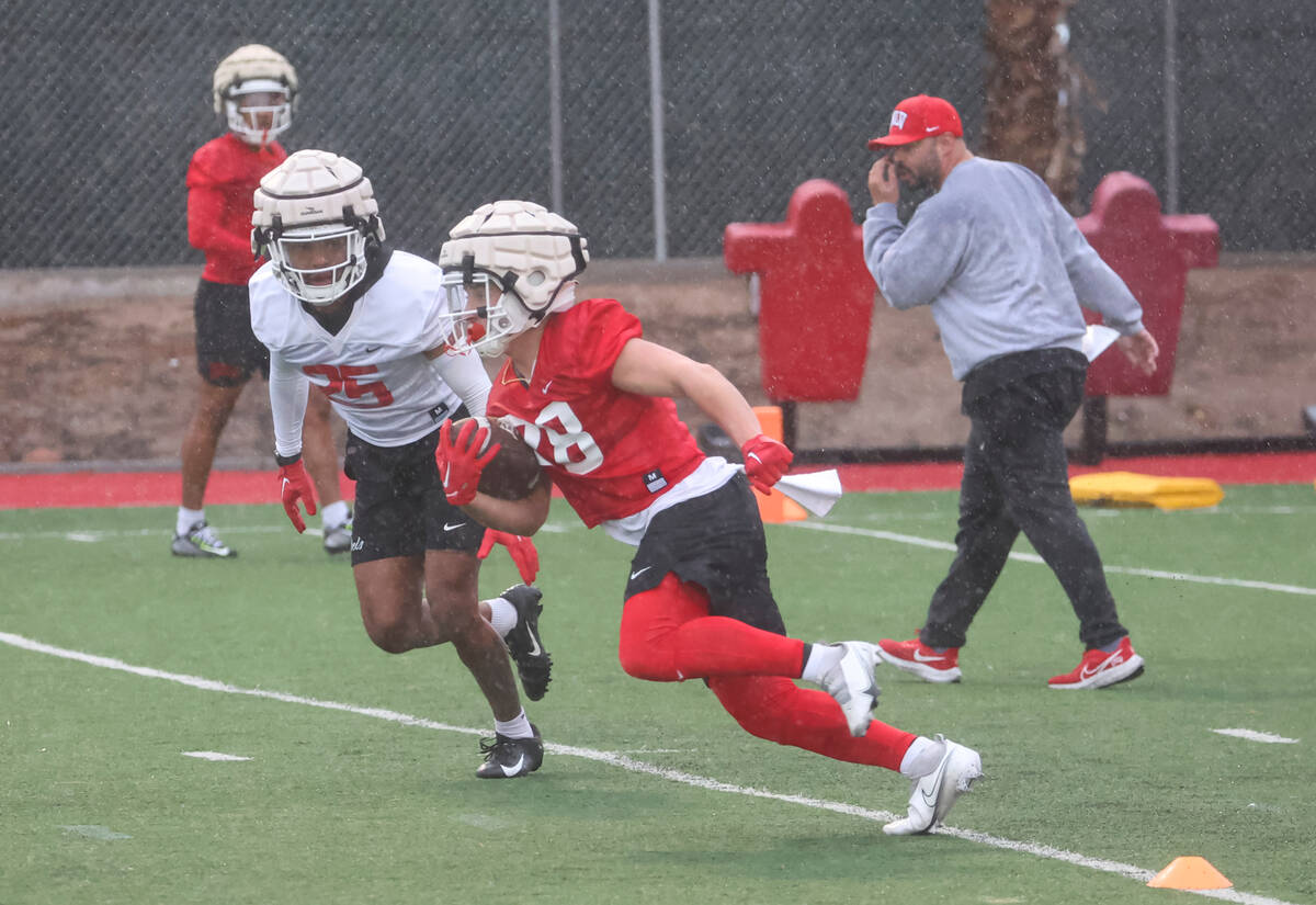 UNLV running back Andrew Wimmer (28) runs the ball under pressure from UNLV defensive back Jord ...