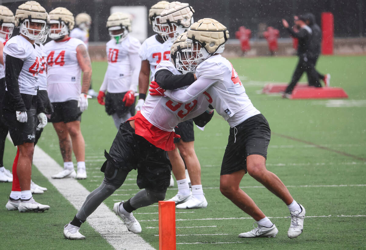 UNLV linebackers LeShaun Bell, left, and Ryan Tuaolo (45) participate in drills during the firs ...