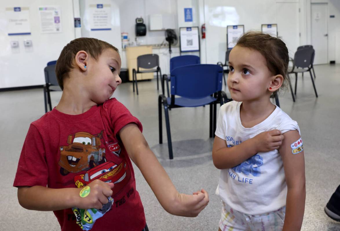 Three-year-old twins Luca, left, and Quincy Yacoub show off their Band-Aids after getting a COV ...