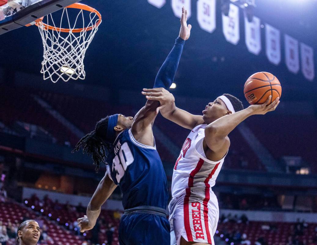 Utah State forward Dan Akin (30) defends as UNLV guard Keyshawn Hall (14) during the first half ...