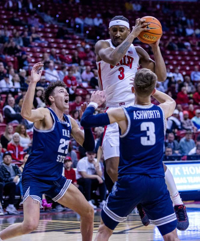 UNLV guard Shane Nowell (3) grabs a rebound between Utah State forward Taylor Funk (23) and Uta ...