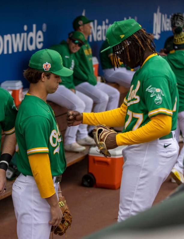 Oakland Athletics center fielder Lawrence Butler (77) works with shortstop Max Muncy (81) befor ...