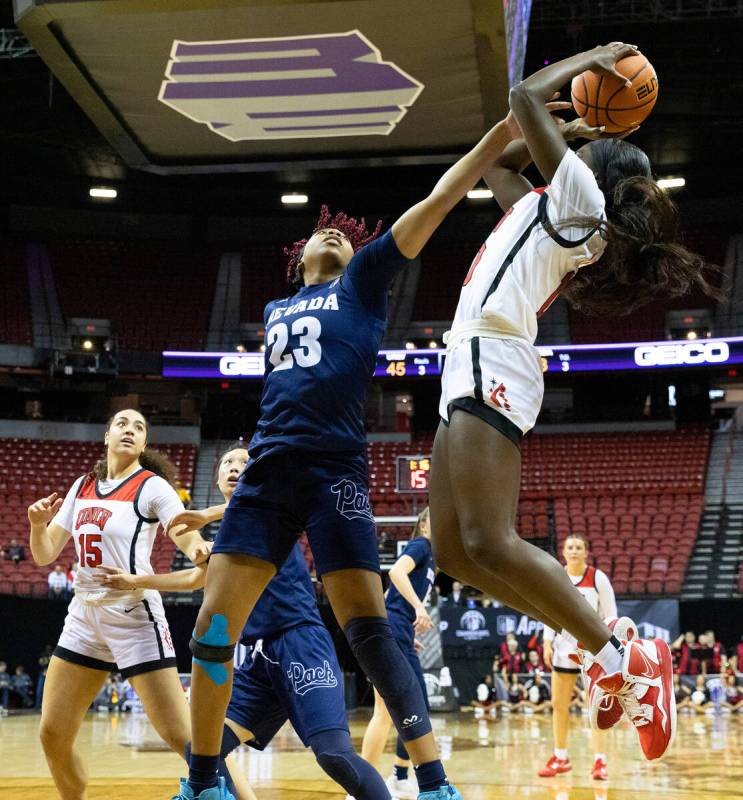 UNLV Lady Rebels guard Jasmyn Lott (10) shoots over Nevada Wolf Pack forward Lexie Givens (23) ...