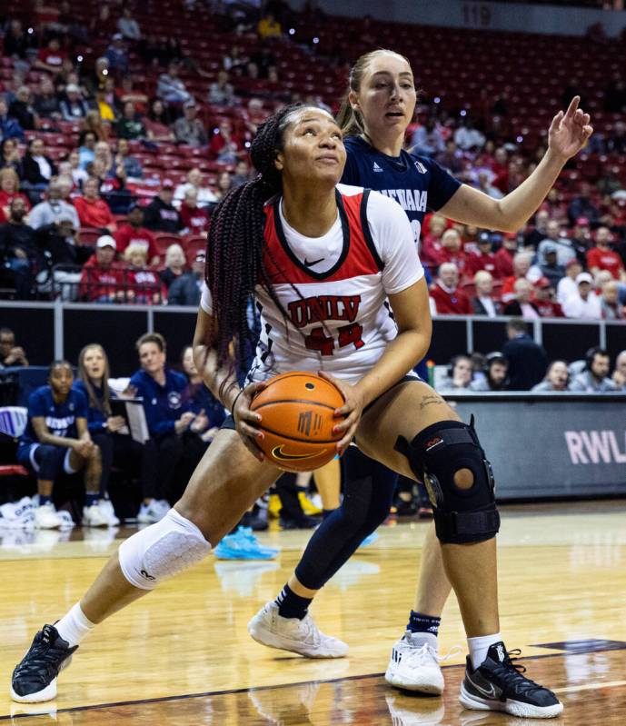 UNLV Lady Rebels forward Alyssa Brown (44) goes for the basket as Nevada Wolf Pack guard Alyssa ...