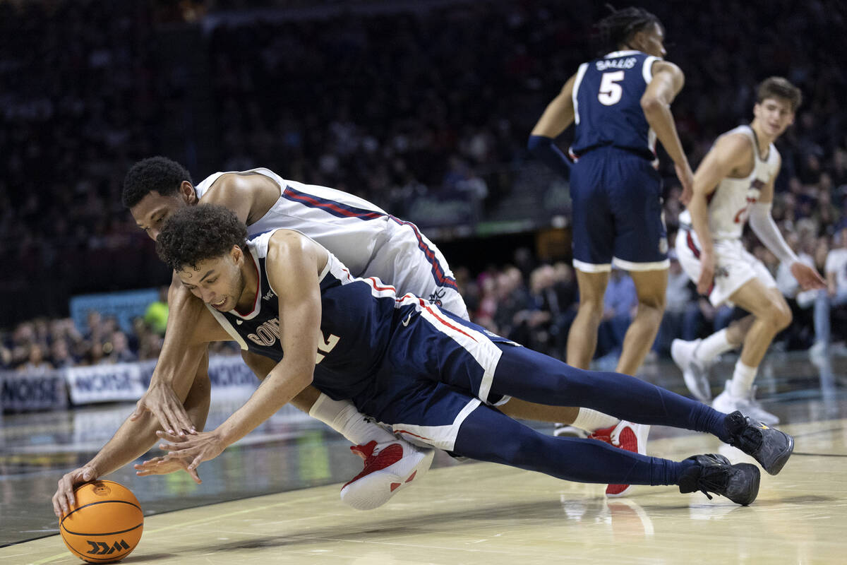 Gonzaga Bulldogs forward Anton Watson (22) dives for the ball to steal possession from St. Mary ...