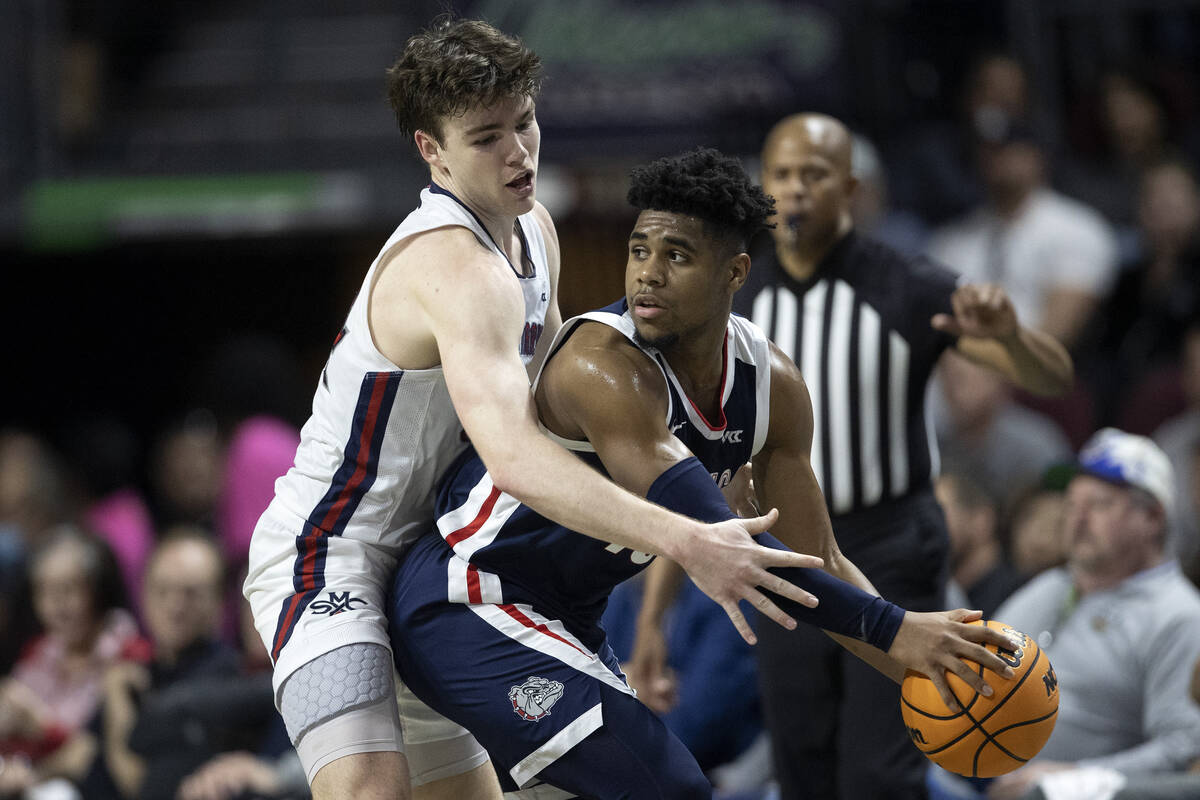 Gonzaga Bulldogs guard Malachi Smith, right, looks to pass around St. Mary's Gaels guard Alex D ...