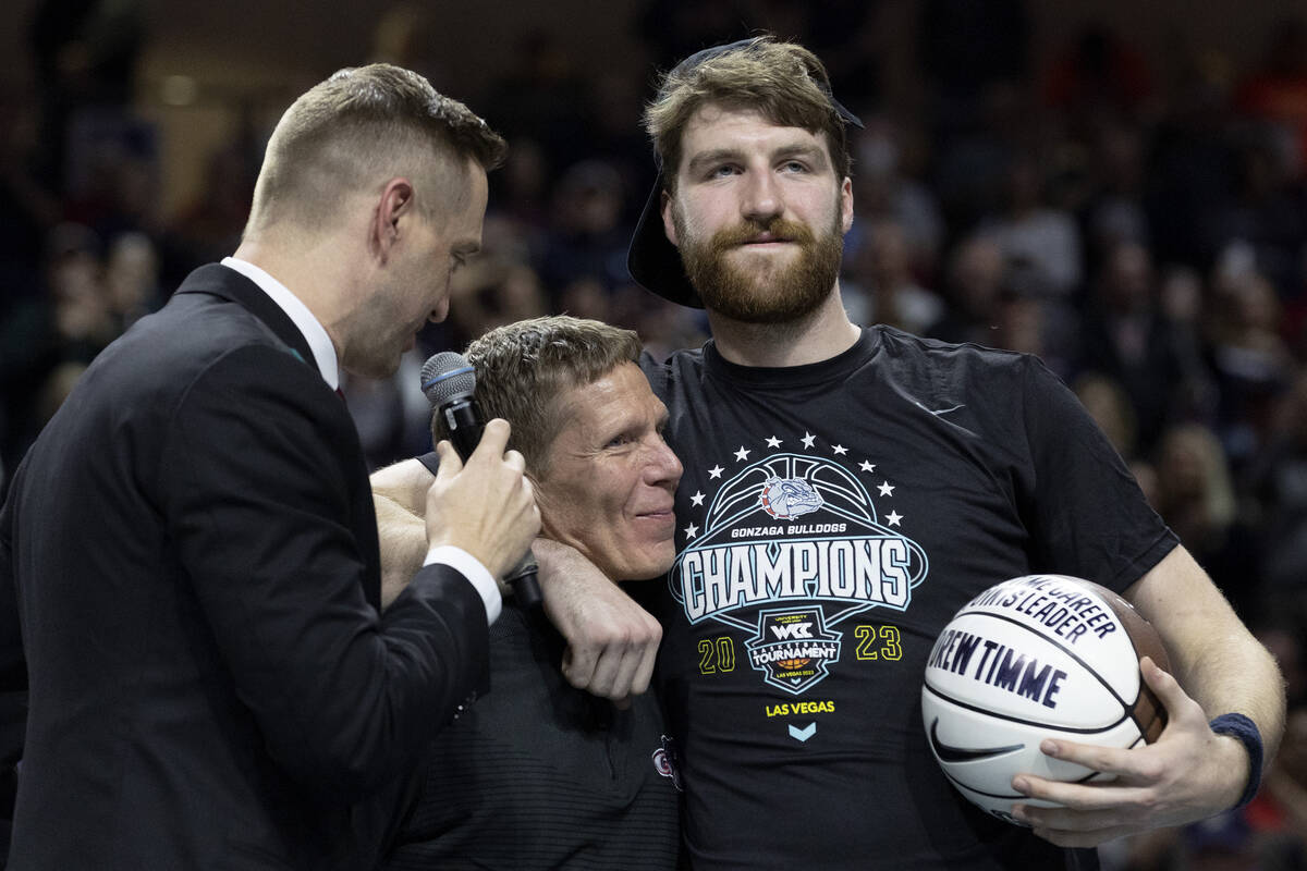 Gonzaga Bulldogs head coach Mark Few hugs forward and leading scorer Drew Timme while presentin ...