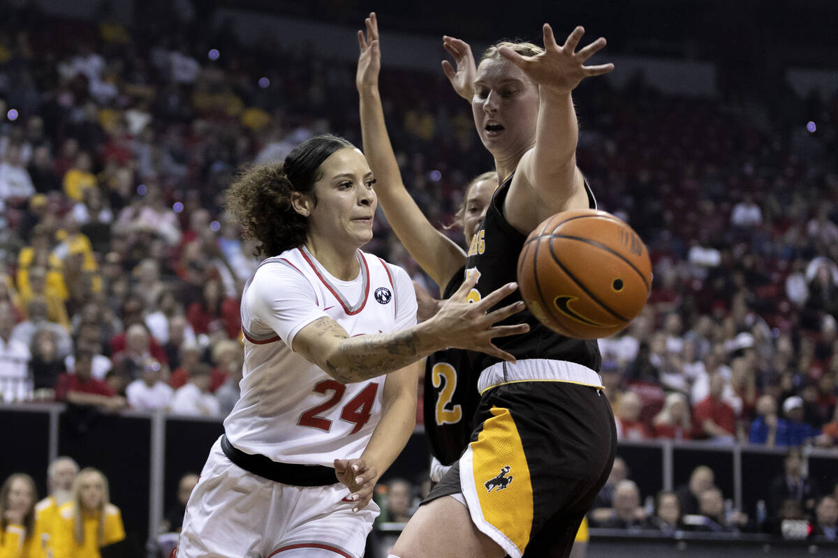 UNLV Lady Rebels guard Essence Booker (24) passes around Wyoming Cowgirls center Allyson Fertig ...