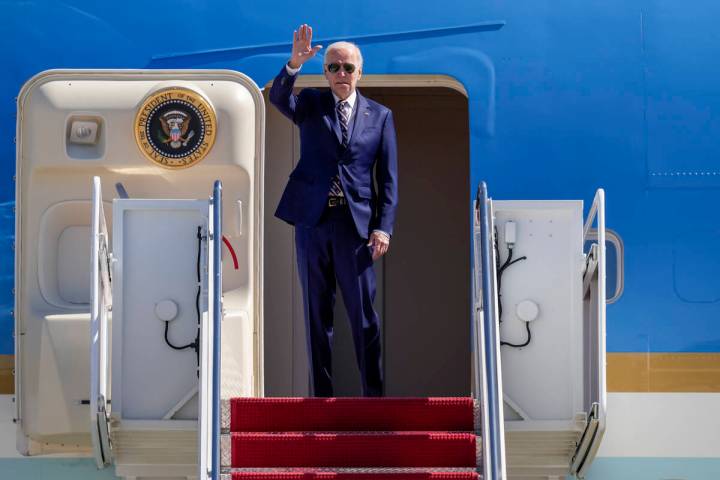 President Joe Biden waves as he boards Air Force One at Andrews Air Force Base, Md., Thursday, ...