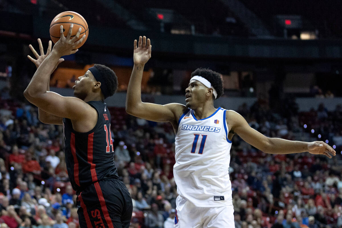 UNLV Rebels guard Keyshawn Hall (14) shoots against Boise State Broncos guard Chibuzo Agbo (11) ...