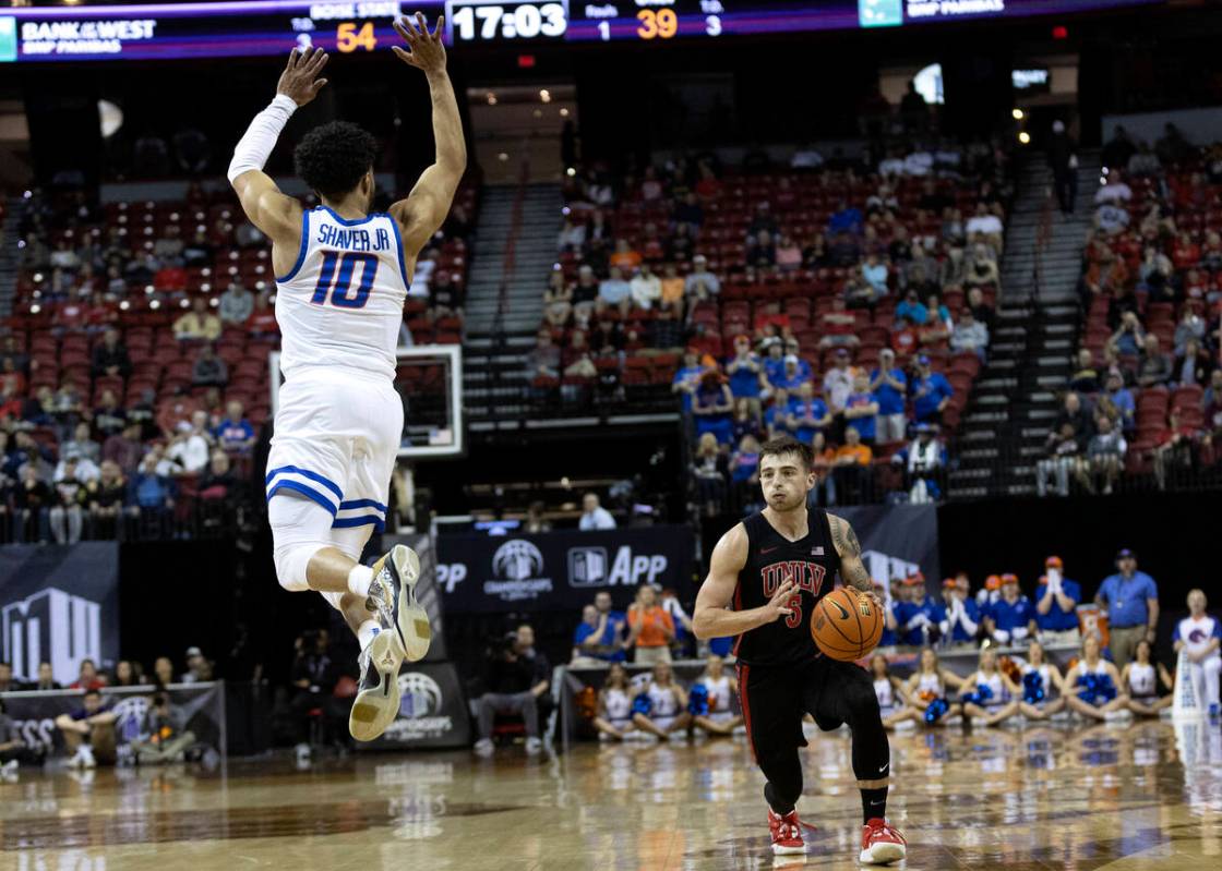 UNLV Rebels guard Jordan McCabe (5) lunges to pass while Boise State Broncos guard Marcus Shave ...