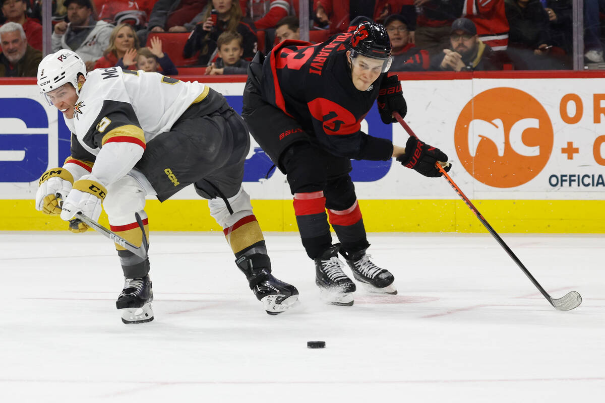 Vegas Golden Knights' Brayden McNabb (3) and Carolina Hurricanes' Jesse Puljujarvi (13) watch t ...