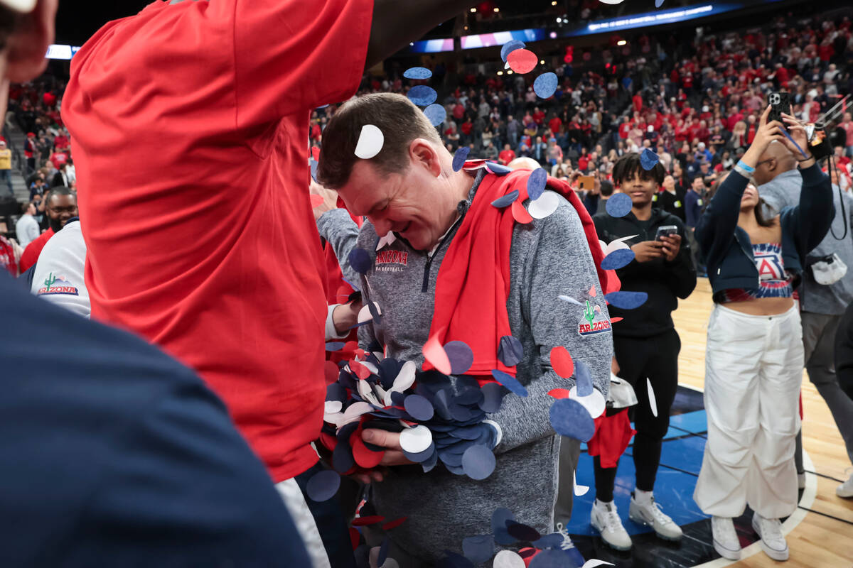 Arizona center Oumar Ballo, left, dumps confetti onto coach Tommy Lloyd while celebrating the t ...