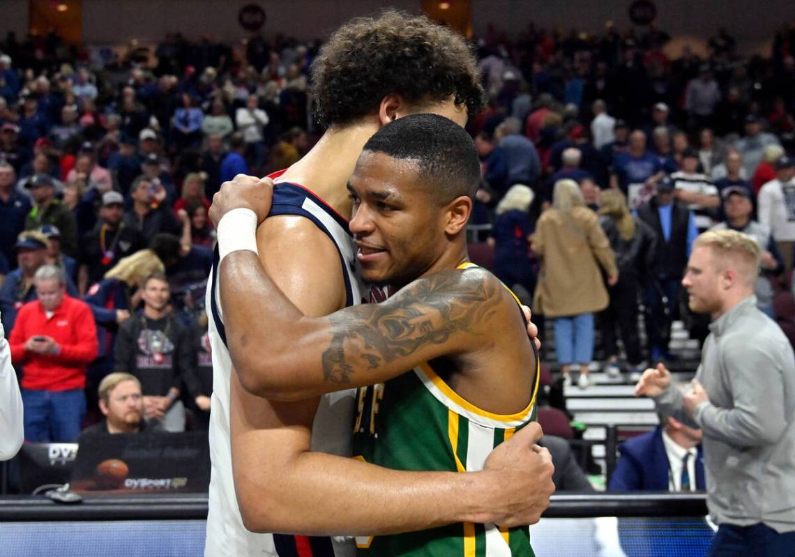 Gonzaga forward Anton Watson, left, and San Francisco guard Khalil Shabazz embrace after an NCA ...