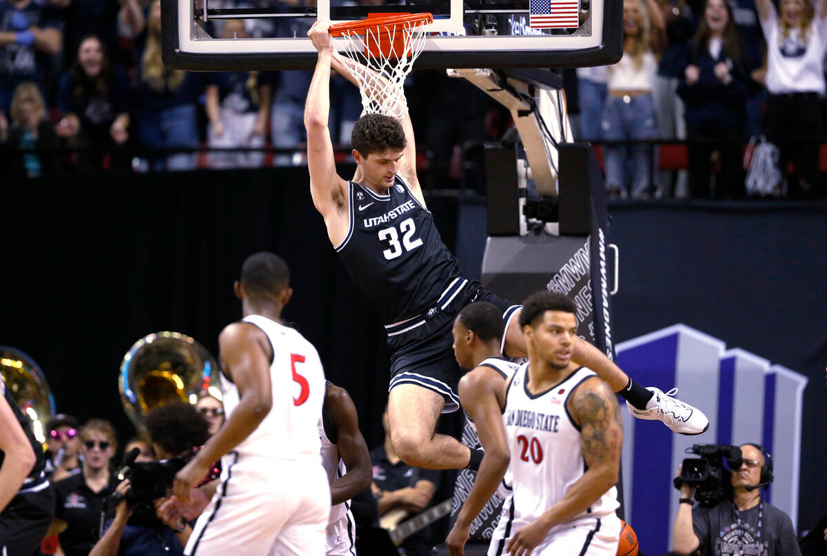 Utah State center Trevin Dorius (32) hangs from the rim after dunking against San Diego State d ...