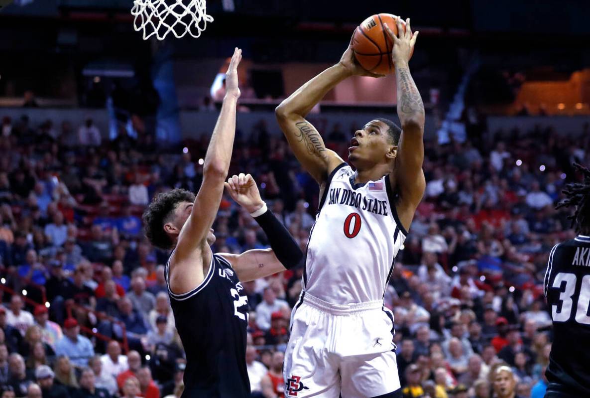 San Diego State forward Keshad Johnson (0) shoots over Utah State forward Taylor Funk (23) duri ...