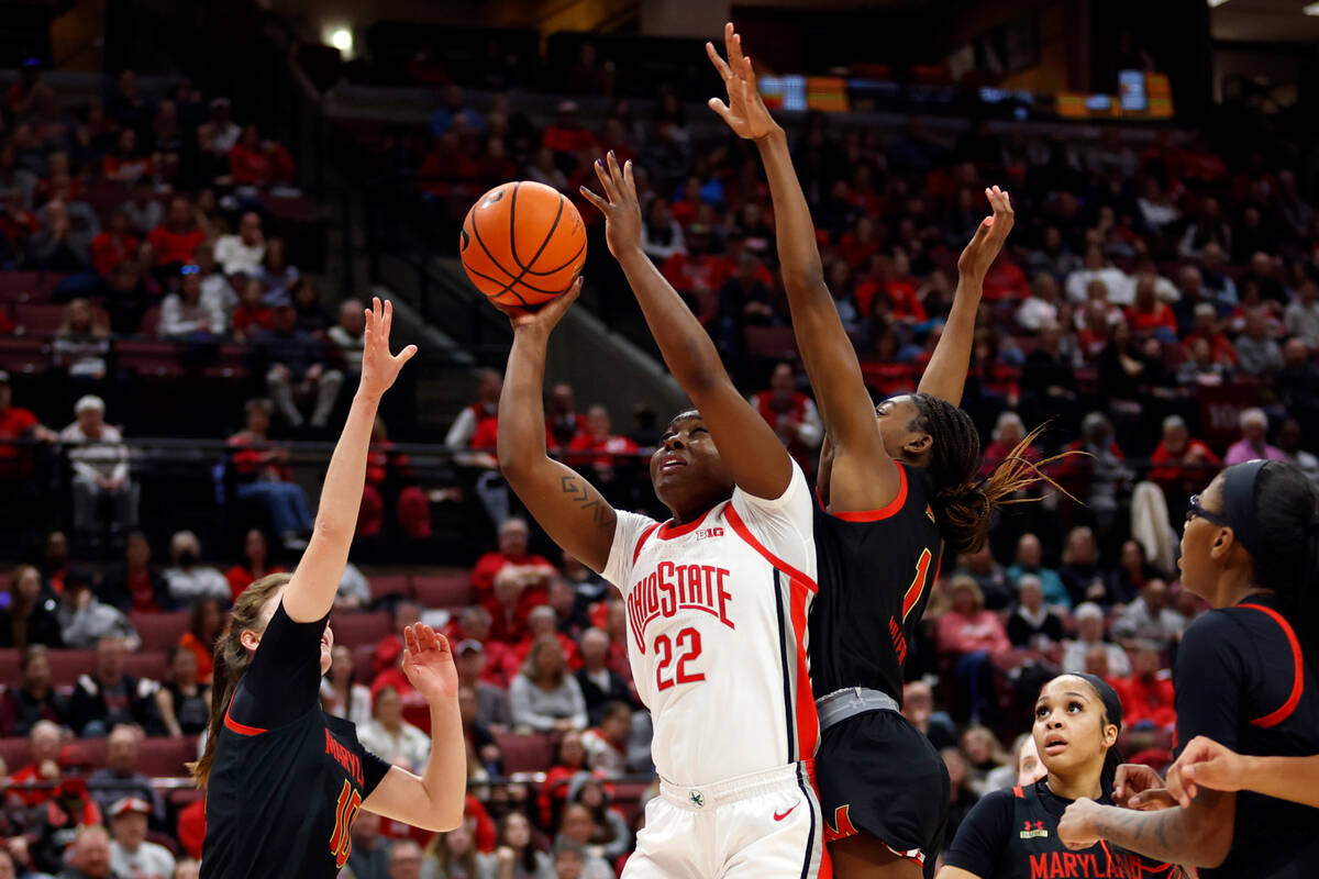 Ohio State forward Eboni Walker, center, shoots between Maryland guard Abby Meyers, left, guard ...