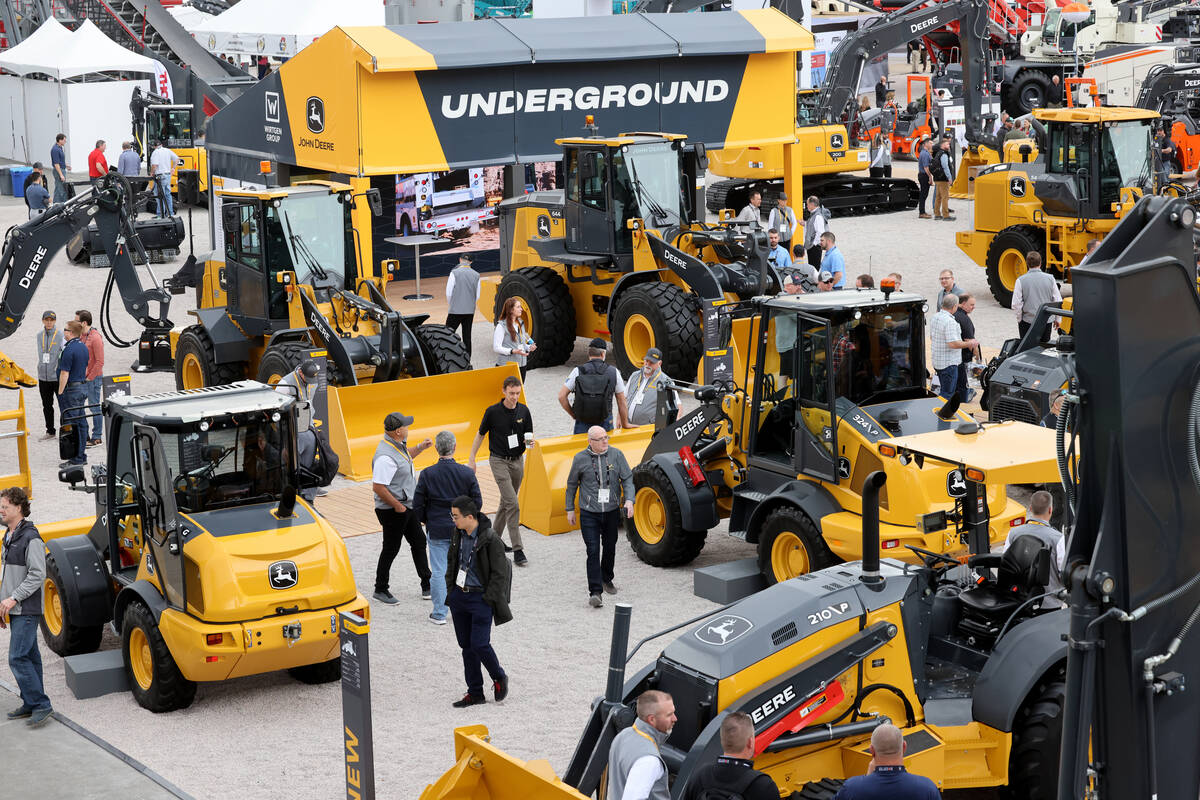 Conventioneers check out products in the John Deere booth at the Las Vegas Convention Center on ...