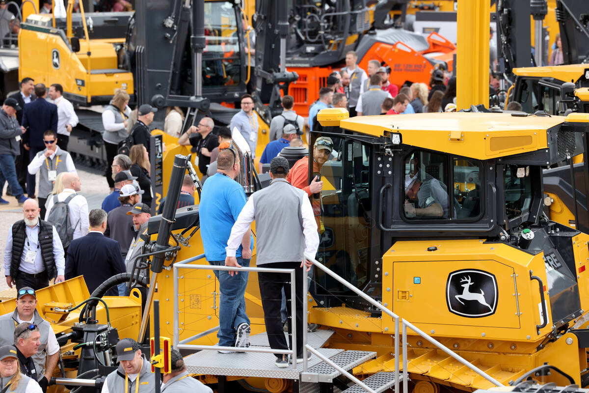 Conventioneers check out products in the John Deere booth at the Las Vegas Convention Center on ...