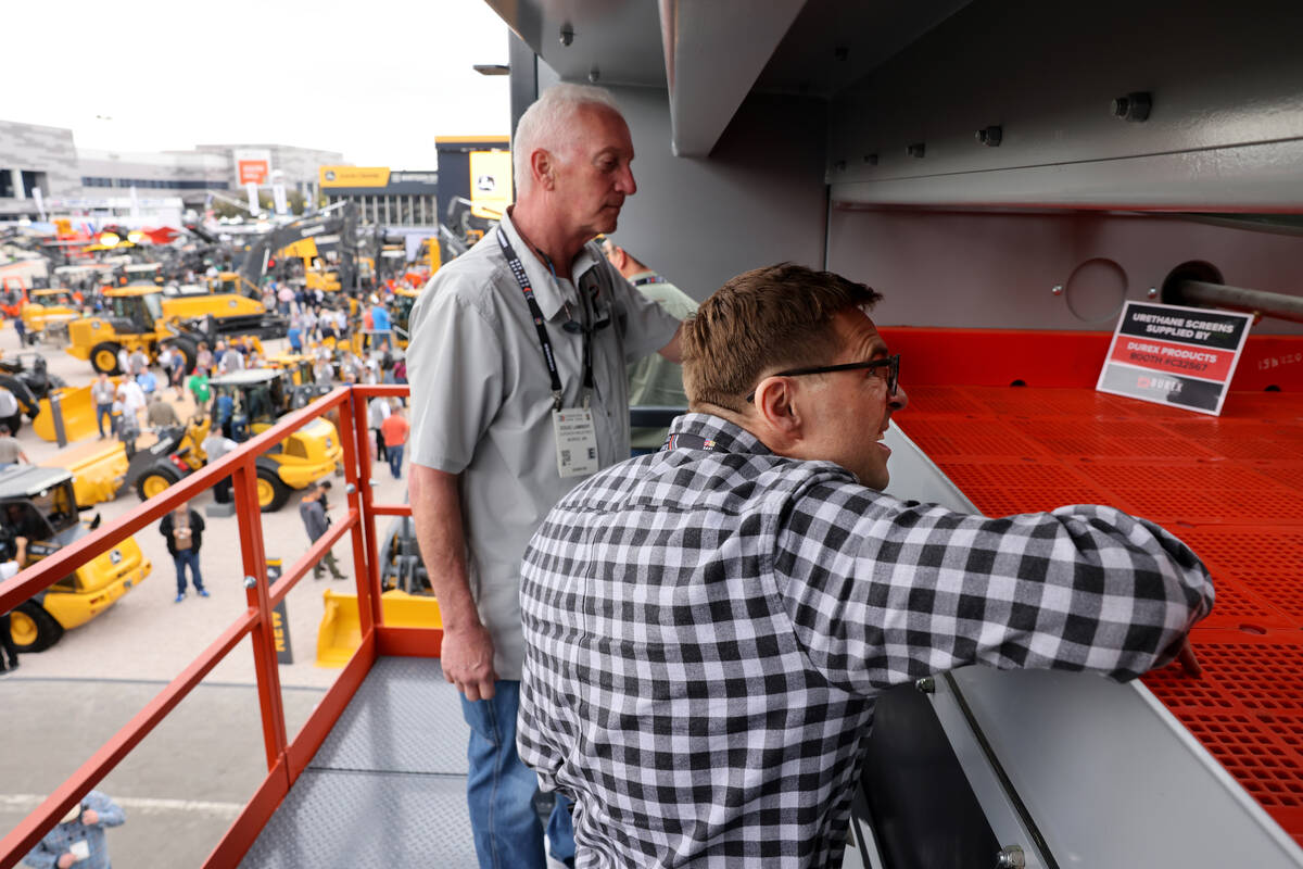 Doug Lambert of Superior Industries from Morris, Minn., left, shows Chris Hawkins of Hawkins Co ...