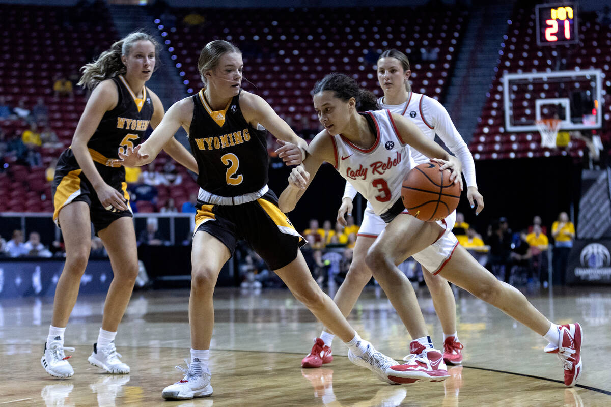 UNLV Lady Rebels guard Kiara Jackson (3) drives around Wyoming Cowgirls guard Emily Mellema (2) ...