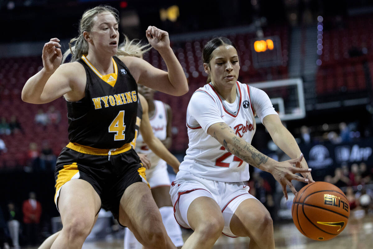 UNLV Lady Rebels guard Essence Booker (24) dribbles while Wyoming Cowgirls forward Grace Ellis ...