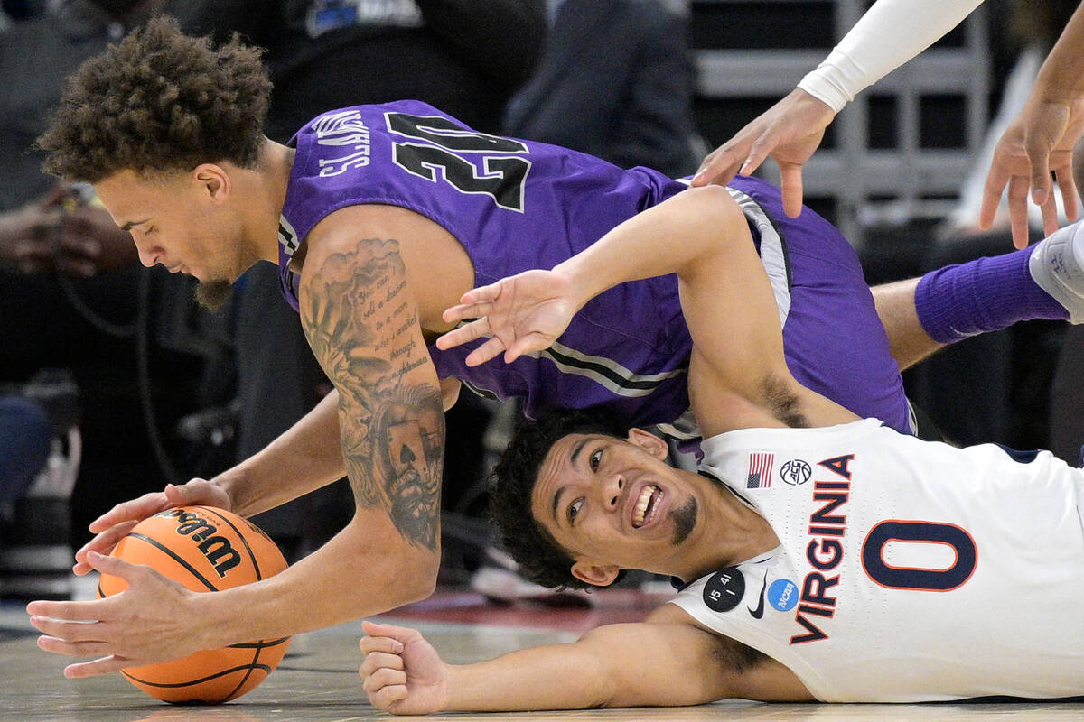 Furman forward Jalen Slawson (20) and Virginia guard Kihei Clark (0) dive on the floor for a lo ...