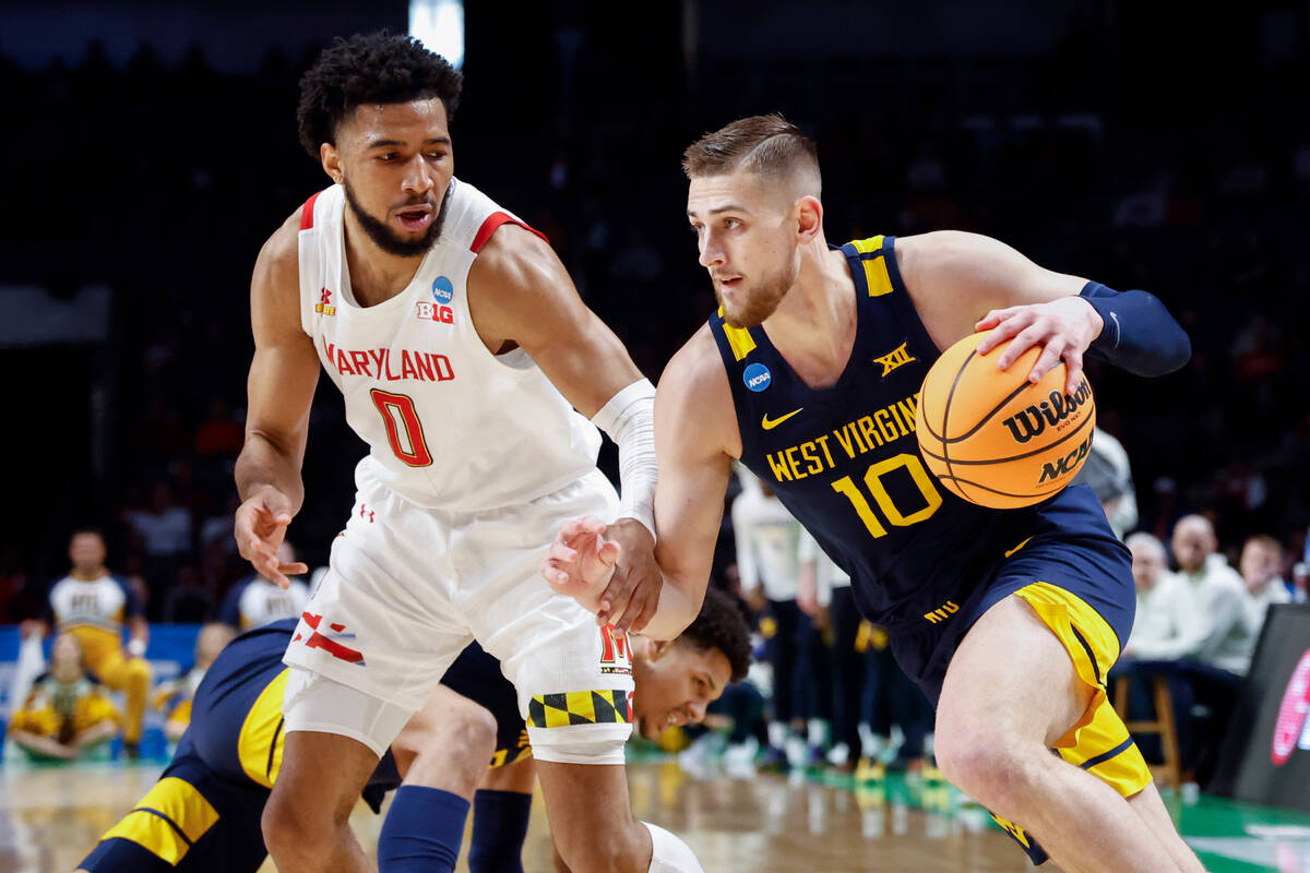 West Virginia guard Erik Stevenson (10) drives around Maryland guard Don Carey (0) in the first ...