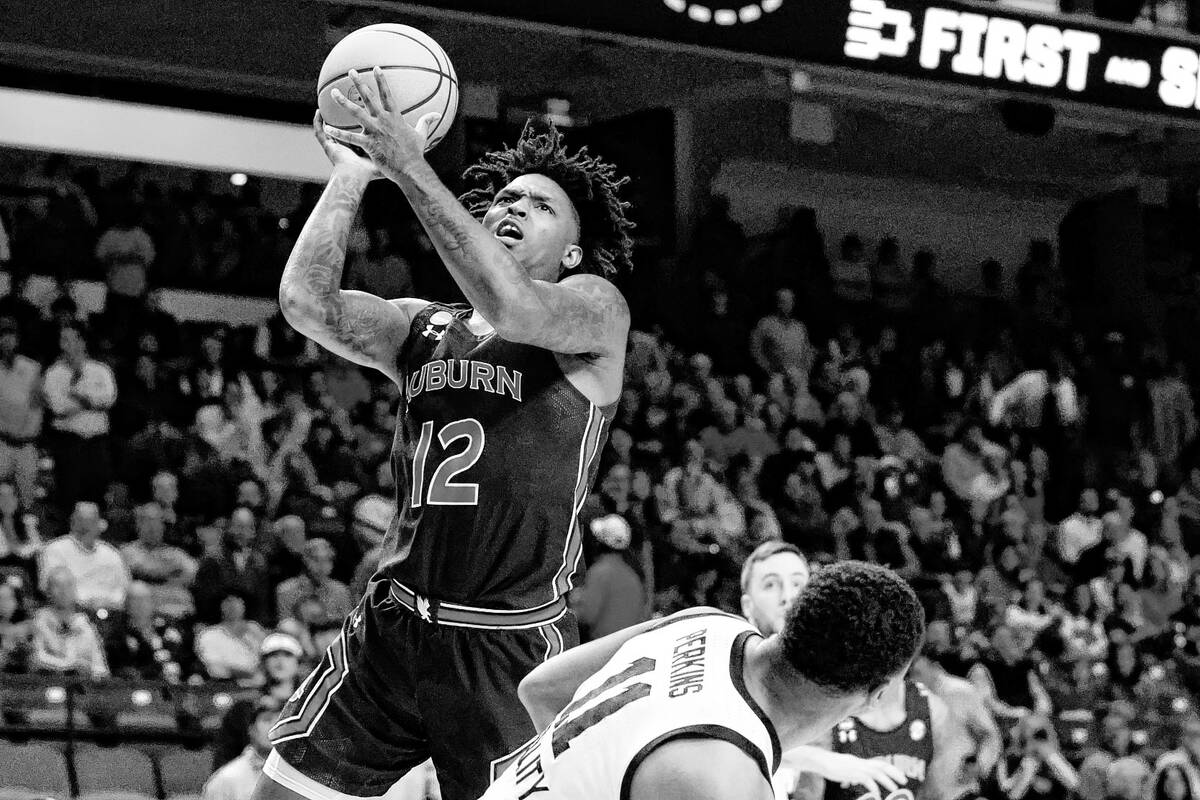 Auburn guard Zep Jasper (12) shoots next to Iowa guard Tony Perkins (11) during the first half ...