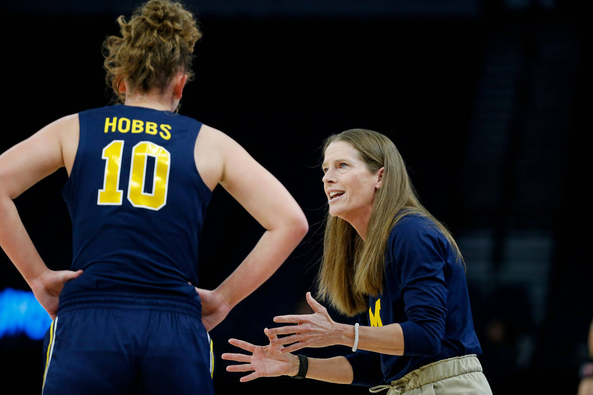 Michigan head coach Kim Barnes Arico, right, speaks with guard Jordan Hobbs (10) in the first h ...