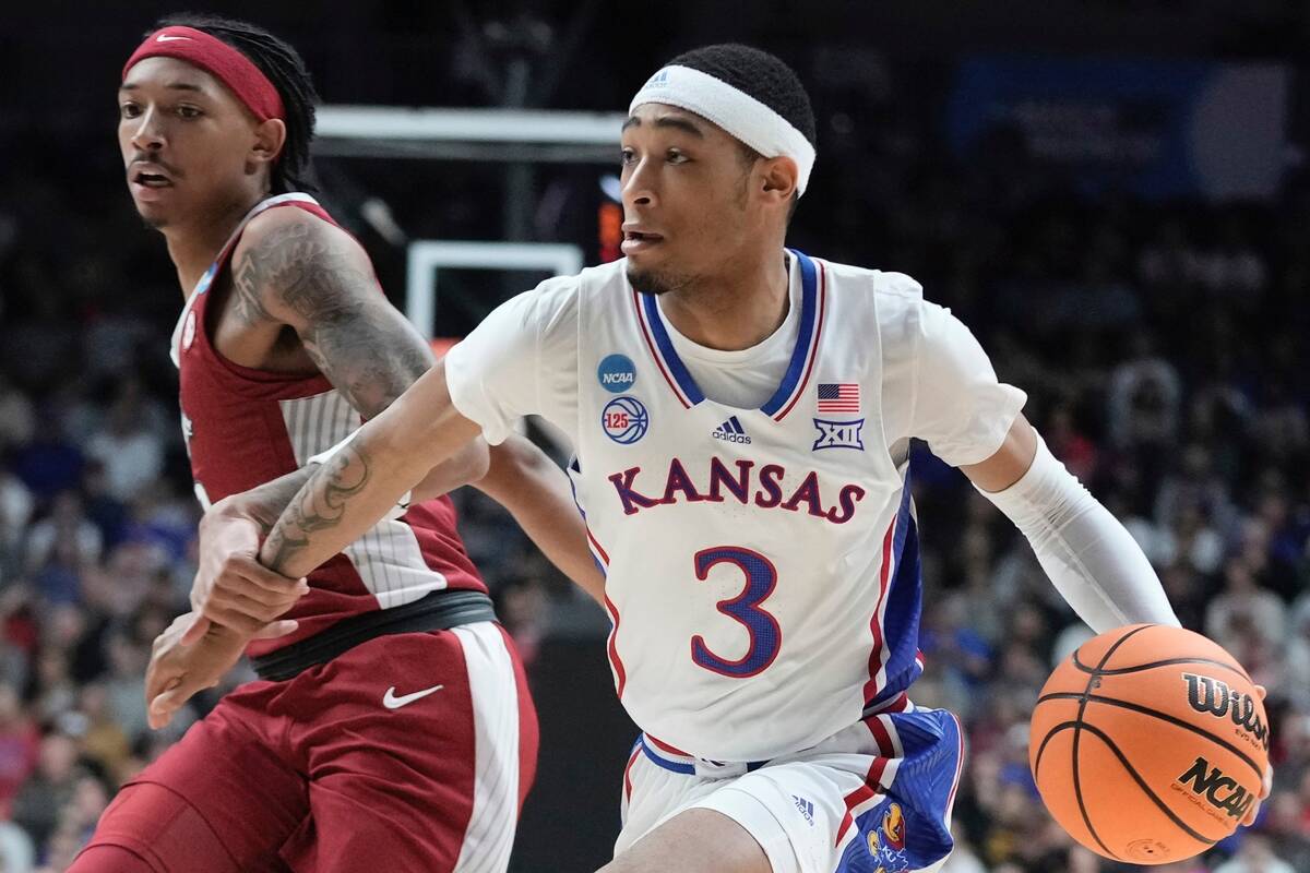 Kansas' Dajuan Harris Jr. drives by Arkansas' Nick Smith Jr. during the first half of a second- ...