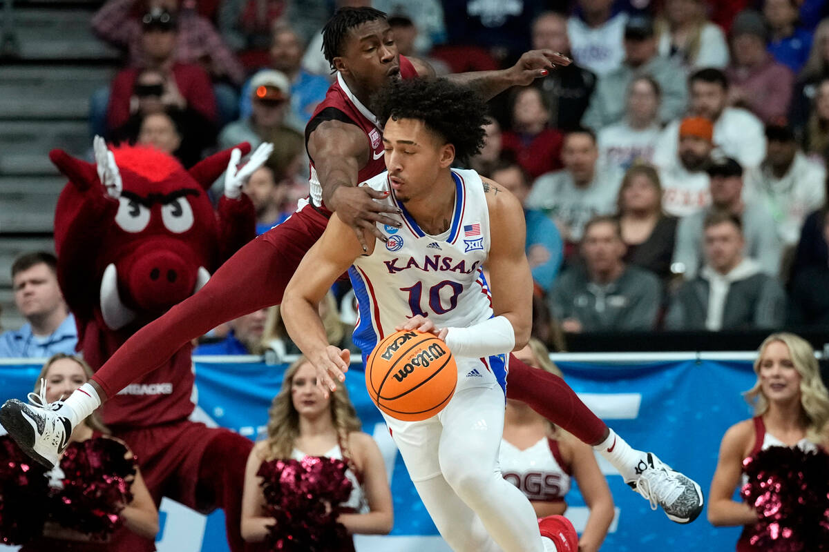 Arkansas guard Davonte Davis, rear, tries to steal the ball from Kansas forward Jalen Wilson (1 ...