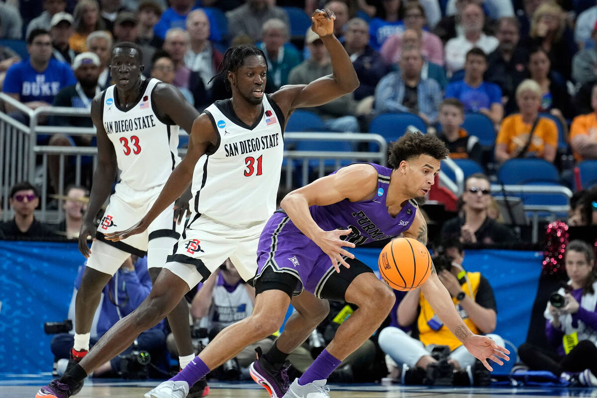 Furman forward Jalen Slawson (20) loses the ball as he drives around San Diego State forwards N ...