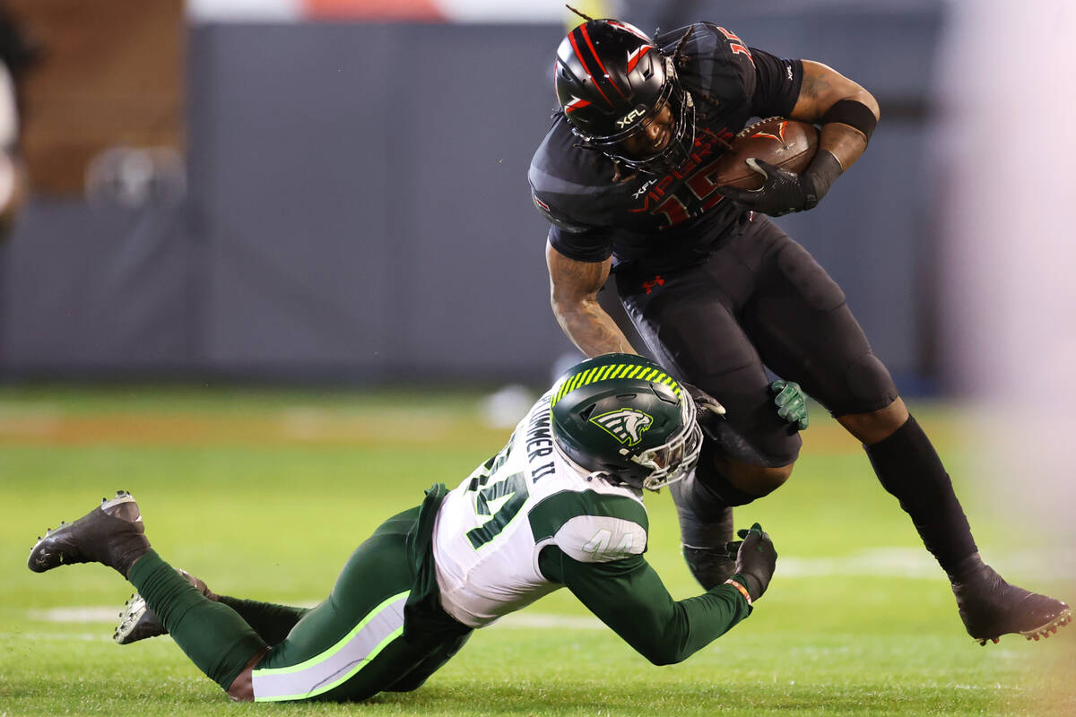 Vegas Vipers running back Rod Smith (15) gets tackled by Orlando Guardians linebacker Terrance ...