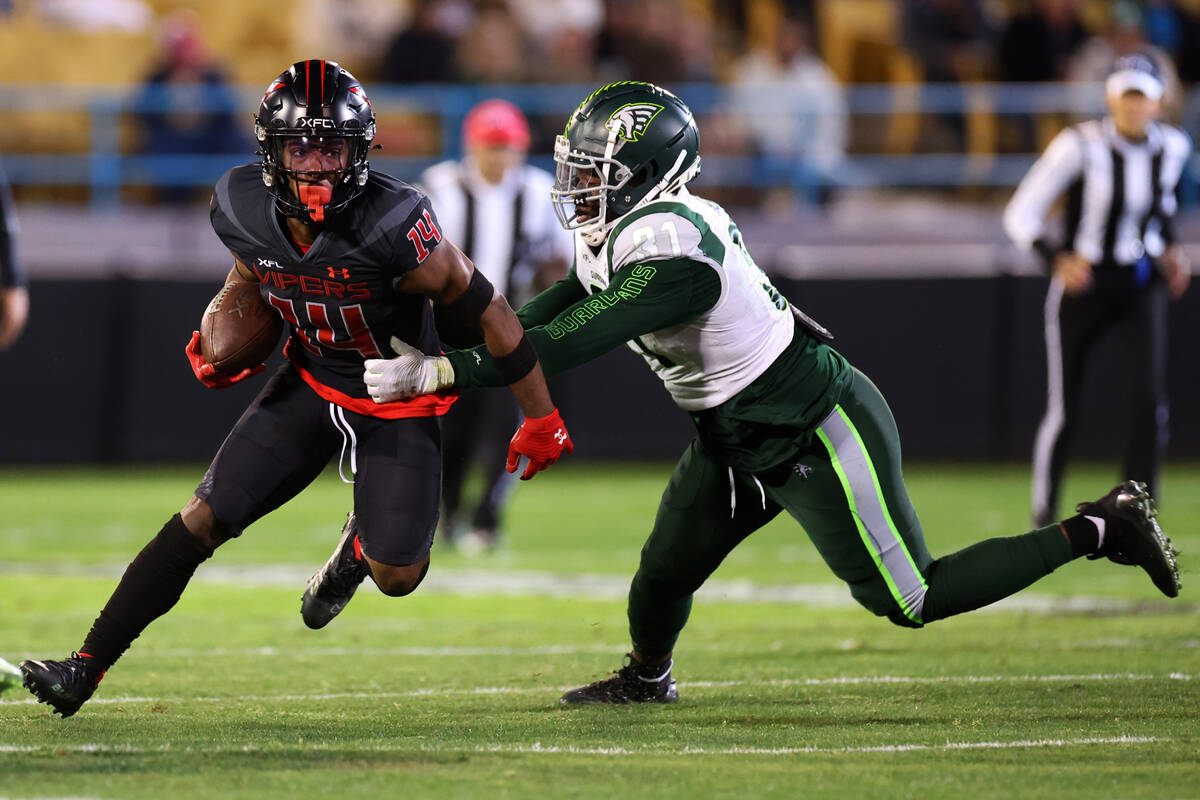 Vegas Vipers wide receiver Cinque Sweeting (14) runs the ball under pressure from from Orlando ...