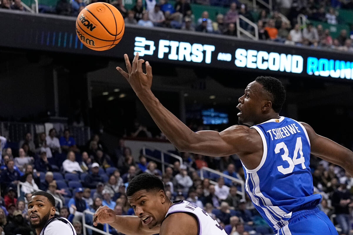 Kentucky forward Oscar Tshiebwe (34) goes over Kansas State forward David N'Guessan (3) for a r ...