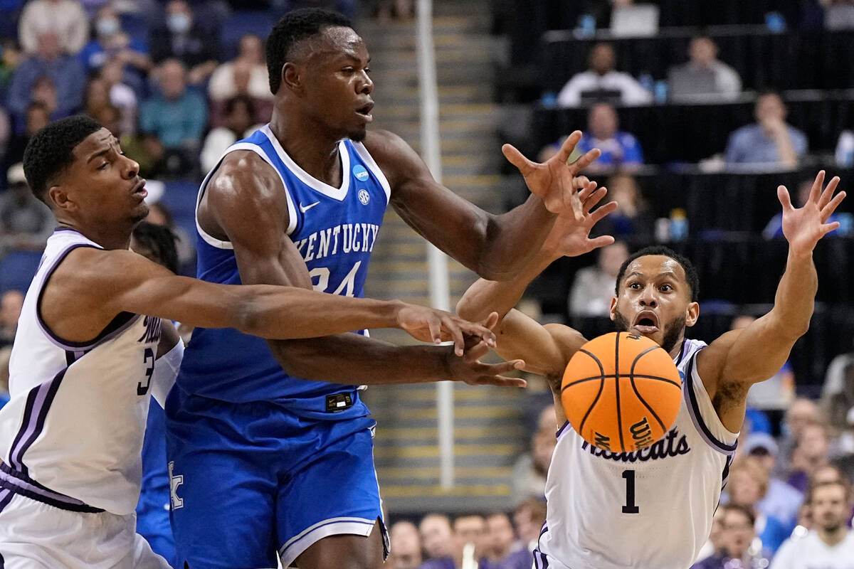 Kentucky forward Oscar Tshiebwe passes between Kansas State forward David N'Guessan and guard M ...