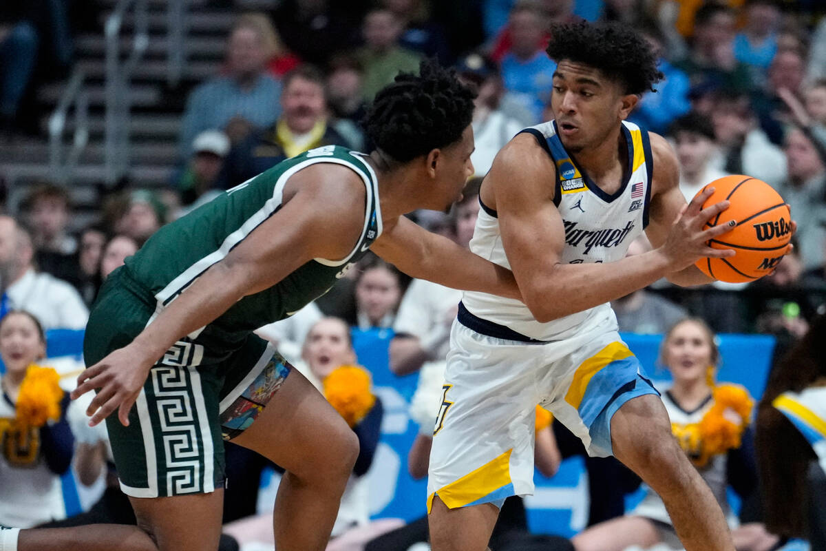 Marquette guard Stevie Mitchell (4) steals the ball from Michigan State guard A.J. Hoggard (11) ...