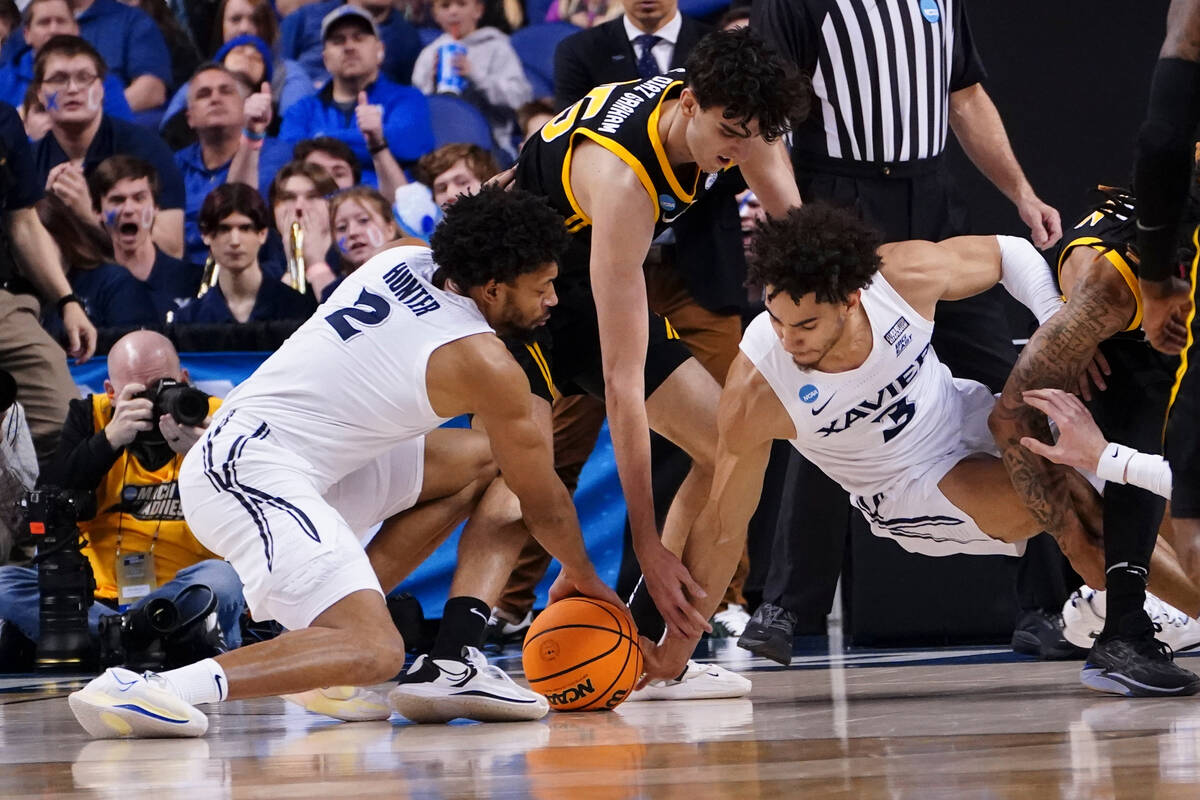 Xavier's Jerome Hunter (2) and Colby Jones (3) battle Pittsburgh forward Guillermo Diaz Graham ...