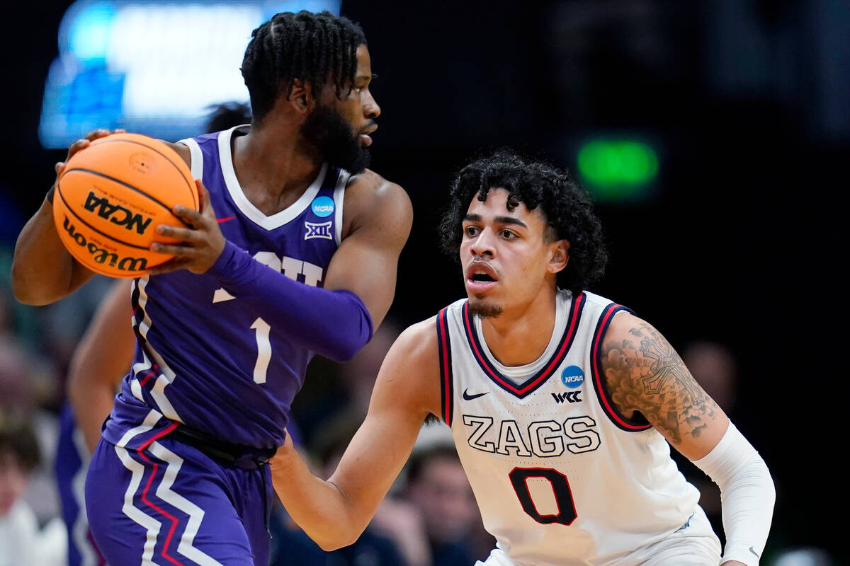 TCU guard Mike Miles Jr., left, looks to pass the ball as Gonzaga guard Julian Strawther defend ...