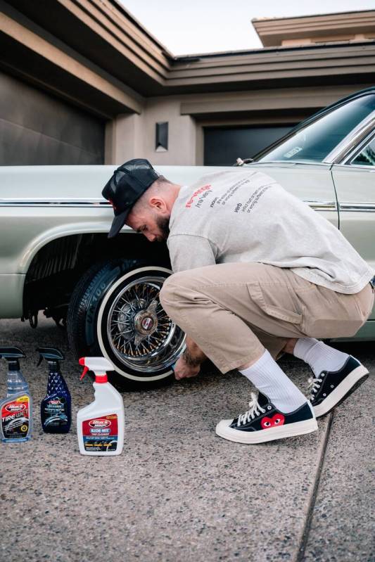 Caleb Plant shines the wire wheels on his 1964 Chevrolet Impala SS Super Sport outside his Las ...