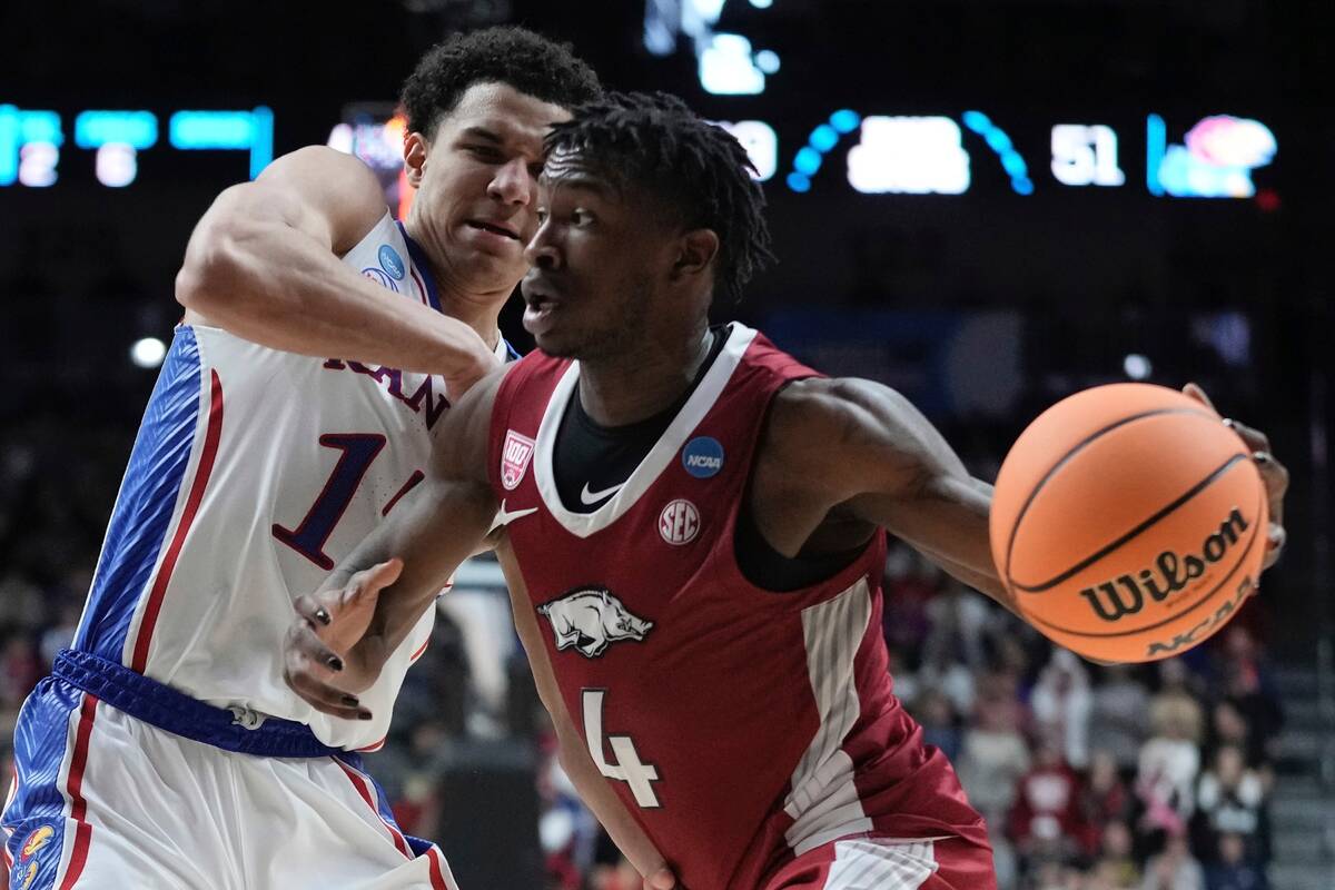 Arkansas' Davonte Davis drives by Kansas' Kevin McCullar Jr. during the second half of a second ...