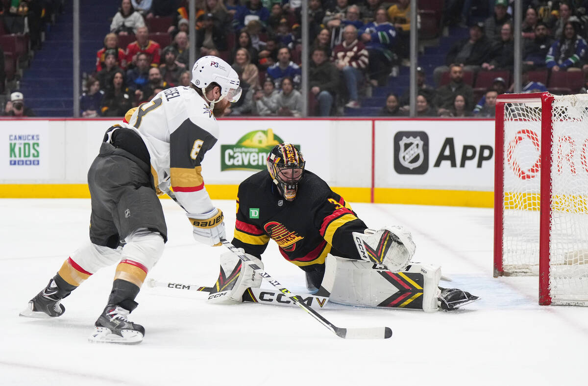 Vegas Golden Knights' Phil Kessel, left, scores against Vancouver Canucks goalie Thatcher Demko ...