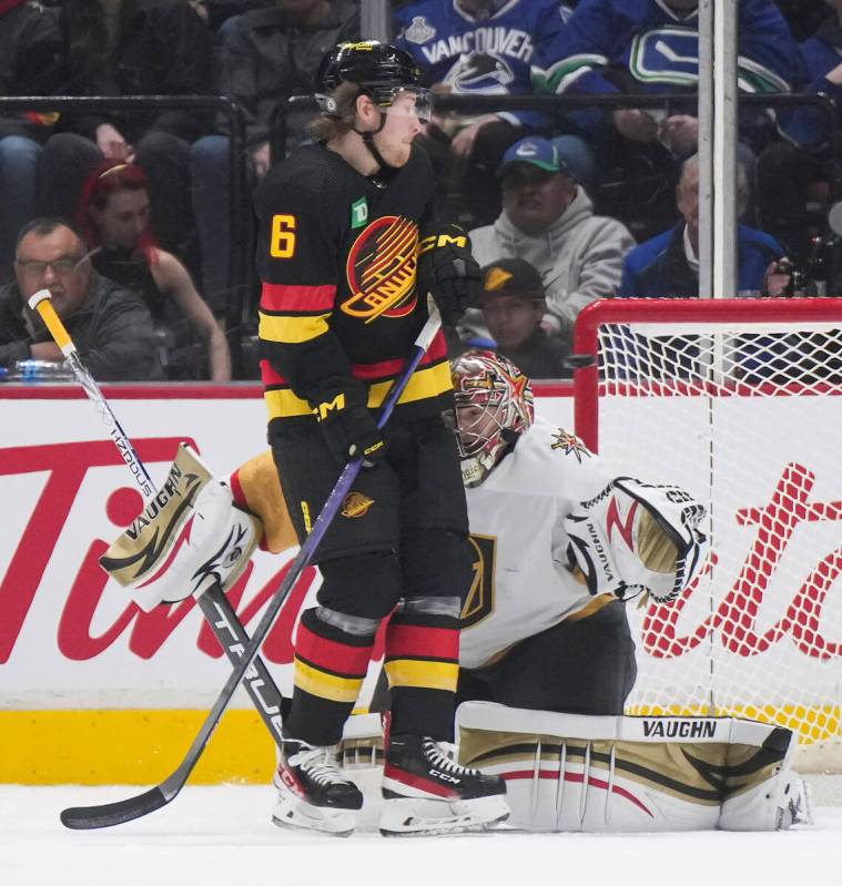 Vegas Golden Knights goalie Jonathan Quick, back, gives up a goal as he's screened by Vancouver ...