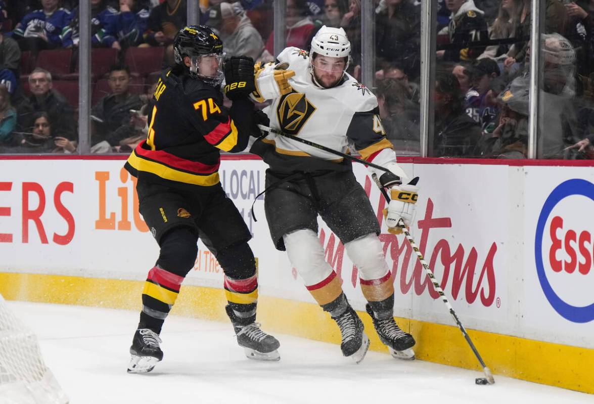 Vancouver Canucks' Ethan Bear, left, checks Vegas Golden Knights' Paul Cotter during the first ...