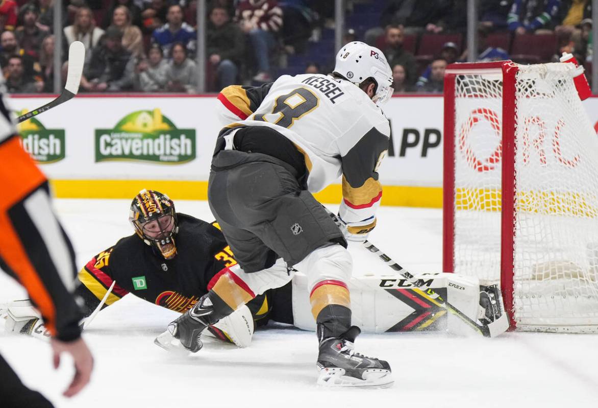 Vegas Golden Knights' Phil Kessel, front, scores against Vancouver Canucks goalie Thatcher Demk ...