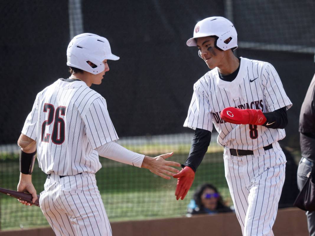 Desert Oasis' Connor Jacob (8) gets a high-five from his teammate Porter Brunn (26) after scori ...