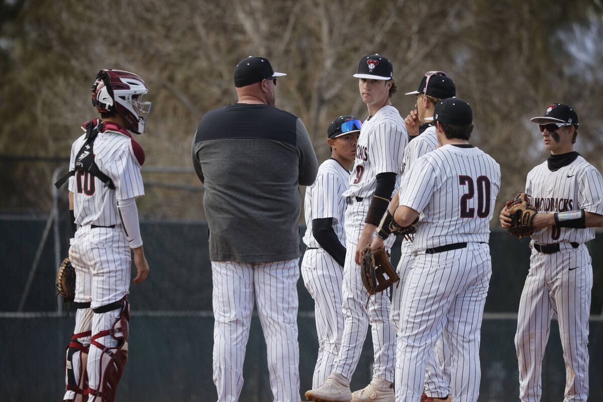 Desert Oasis' head coach Paul Buboltz second from left, talks with Desert Oasis' Seth Graham-Pi ...